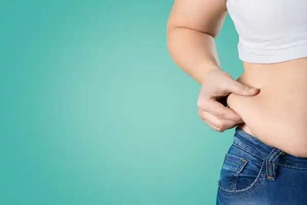Image of woman pinching her love handles to show weight gain Swadlincote